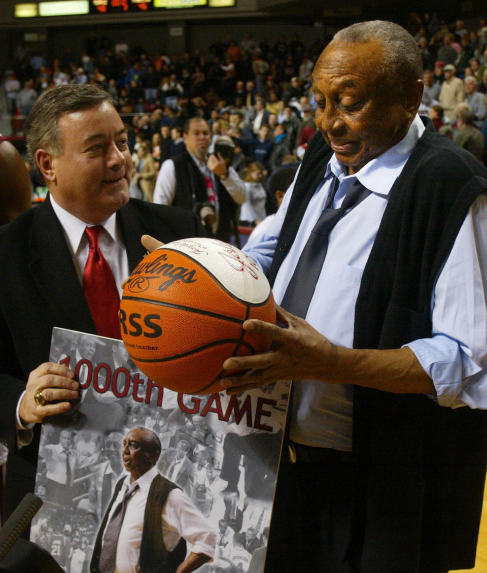 FILE - Temple head coach John Chaney, right, is presented with a ball by Temple athletic director Bill Bradshaw commemorating his 1000th game coached, in Philadelphia, in this Monday, Dec. 20, 2004, file photo. Temple beat Princeton 48-46. John Chaney, one of the nation’s leading Black coaches and a commanding figure during a Hall of Fame basketball career at Temple, has died. He was 89. His death was announced by the university Friday, Jan. 29, 2021. (AP Photo/Miles Kennedy, File)