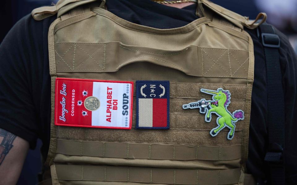  In this file photo a member of the far-right militia, Boogaloo Bois, walks next to protestors demonstrating outside Charlotte Mecklenburg Police Department Metro Division 2 just outside of downtown Charlotte, North Carolina, on May 29, 2020 - Logan Cyrus/AFP/Getty