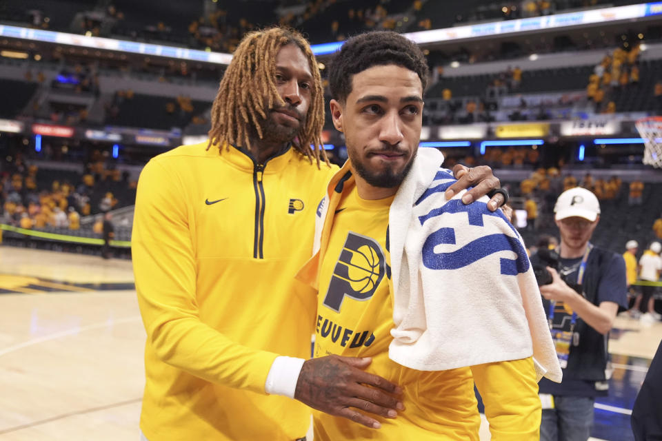 Indiana Pacers guard Tyrese Haliburton, right, walks off the court with teammate James Johnson, left, after Game 6 against the Milwaukee Bucks in an NBA basketball first-round playoff series, Thursday, May 2, 2024, in Indianapolis. The Pacers won 120-98. (AP Photo/Michael Conroy)