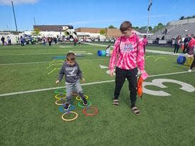 Fairless first grader Austin Swihart, 7, finishes the obstacle course at the 37th annual Exceptional Olympics while his buddy Killian Mayfield, a Fairless High School sophomore, cheers him on.
