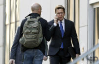 Mark Lanier, right, an attorney for the plaintiffs, enters the U.S. Federal courthouse, Monday, Oct. 21, 2019, in Cleveland. The nation's three dominant drug distributors and a big drugmaker have reached a tentative deal to settle a lawsuit related to the opioid crisis just as the first federal trial over the crisis was due to begin Monday, according to a lead lawyer for the local governments suing the drug industry. (AP Photo/Tony Dejak)