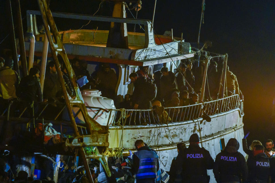 Police check a fishing boat with some 500 migrants in the southern Italian port of Crotone, early Saturday, March 11, 2023. The Italian coast guard was responding to three smugglers boats carrying more than 1,300 migrants “in danger” off Italy’s southern coast, officials said Friday. Three small coast guard boats were rescuing a boat with 500 migrants about 70 nautical miles off the Calabria region, which forms the toe of the Italian boot. (AP Photo/Valeria Ferraro)