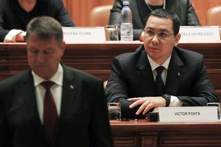 Romanian Prime Minister Victor Ponta (R) looks on as new President Klaus Iohannis walks to takes his oath during a swearing-in ceremony in front of the Parliament in Bucharest December 21, 2014. REUTERS/Radu Sigheti