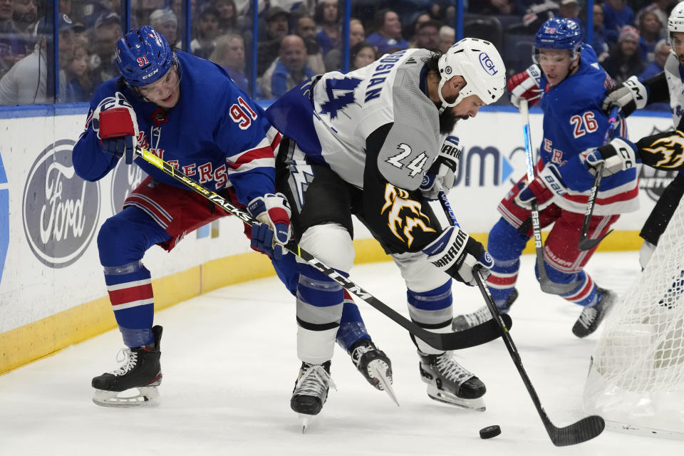 Tampa Bay Lightning defenseman Zach Bogosian (24) controls the puck in front of New York Rangers left wing Sammy Blais (91) during the first period of an NHL hockey game Thursday, Dec. 29, 2022, in Tampa, Fla. (AP Photo/Chris O'Meara)