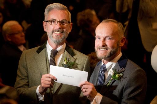 Andrew Wale y Neil Allard exhiben su certificado de boda en la localidad inglesa de Brighton (sur), la madrugada del 29 de marzo de 2014, apenas entrada en vigor la ley que autoriza el matrimonio homosexual en Inglaterra y Gales (AFP | Leon Neal)