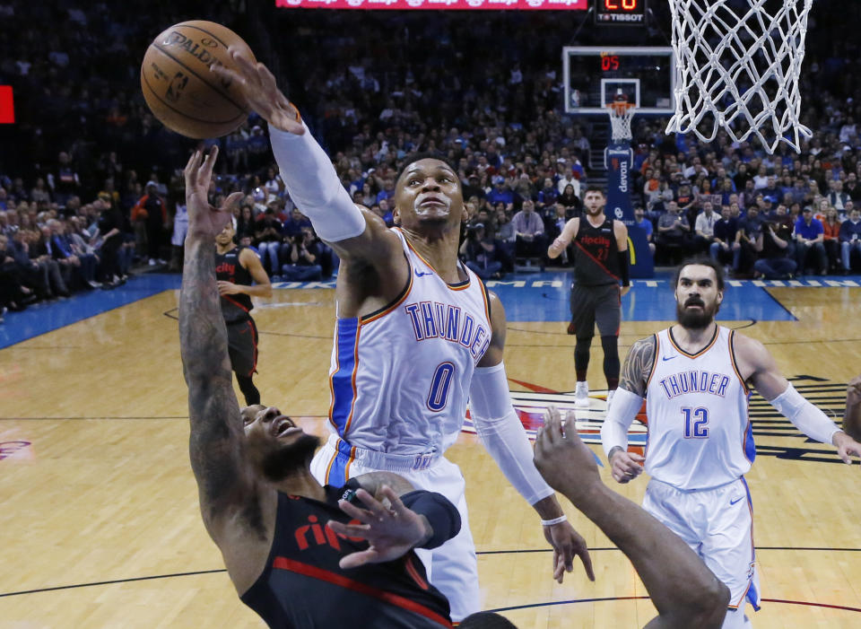 Oklahoma City Thunder guard Russell Westbrook (0) blocks a shot by Portland Trail Blazers guard Damian Lillard, left, in the first half of an NBA basketball game in Oklahoma City, Monday, Feb. 11, 2019. (AP Photo/Sue Ogrocki)