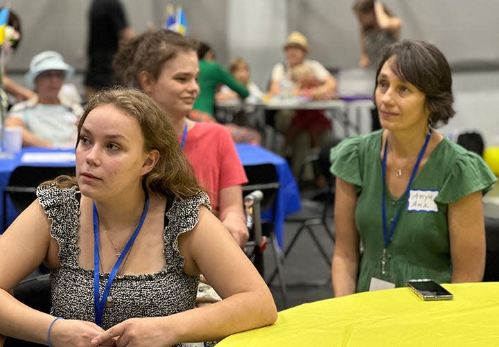 Katya Hopp, from left, her sister Vika Hopp and their mother Anya Hopp listen to performers Saturday at Hill Country Bible Church where Ukrainian refugees received a 'welcome box' from Cru City Austin and Texas 4 Ukraine.