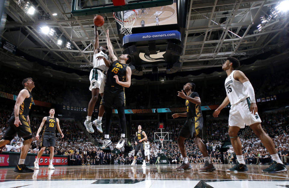 Michigan State's Aaron Henry, top left, goes up for a shot against Iowa's Ryan Kriener (15) during the second half of an NCAA college basketball game, Tuesday, Feb. 25, 2020, in East Lansing, Mich. Michigan State won 78-70. (AP Photo/Al Goldis)