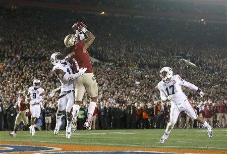 Florida State Seminoles Kelvin Benjamin (C) catches the game winning touchdown pass while being covered by Auburn Tigers Chris Davis (L) in the fourth quarter during the BCS Championship football game in Pasadena, California January 6, 2014. REUTERS/Lucy Nicholson