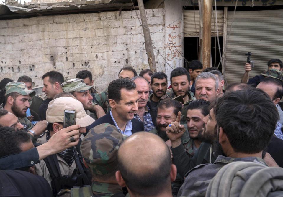 Syrian President Bashar Assad, center, speaks with Syrian troops near Damascus