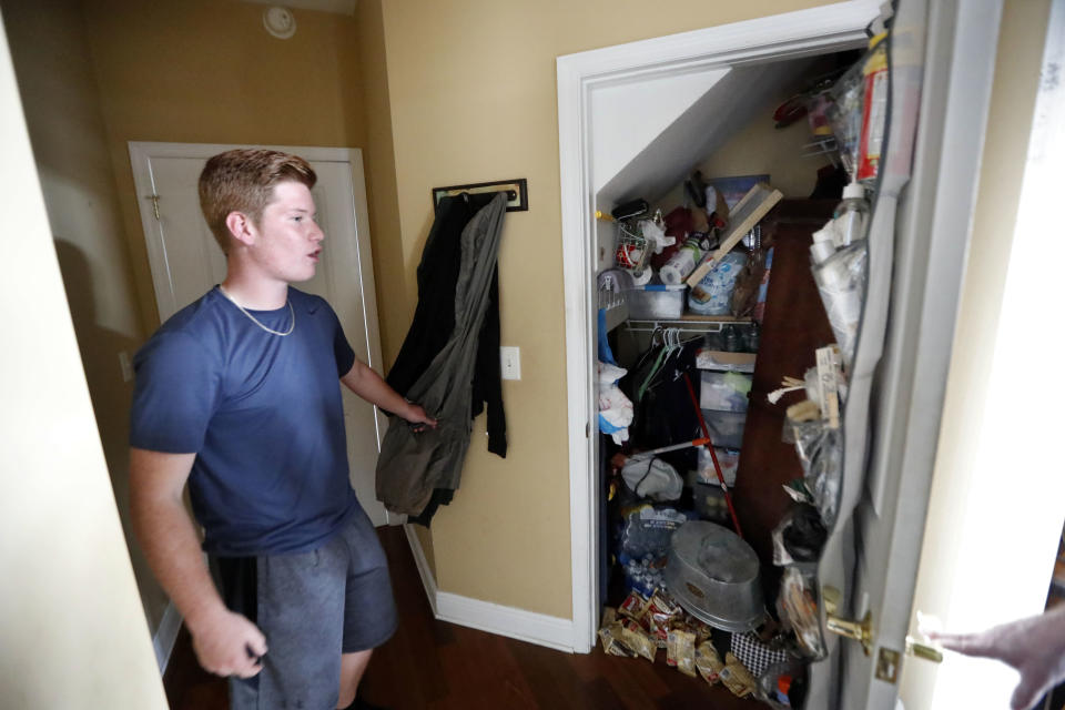 Mike Maddox, quarterback for the Mosley High football team, shows the closet in which he hid with three adults and five dogs during Hurricane Michael, in his damaged home, in Lynn Haven, Fla., Friday, Oct. 19, 2018. (AP Photo/Gerald Herbert)