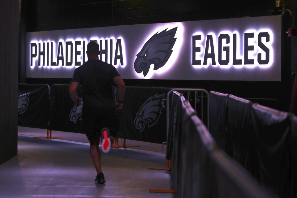 FILE - In this Thursday, Aug. 19, 2021, file photo, a Philadelphia Eagles' player runs back to the locker room before a preseason NFL football game against the New England Patriots in Philadelphia. The NFL has mandated that only fully vaccinated personnel, with a maximum of 50 people, will have access to locker rooms while players are present on game days. Players are not required to be vaccinated against COVID-19, but the NFL has reported that more than 90% of them are. (AP Photo/Rich Schultz, File)