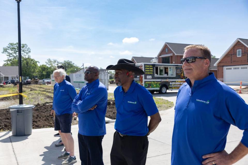 Employees at faith-based nonprofit Lansdowne Up stand and watch a presentation of the new neighborhood they helped build in East St. Louis, Ill. on May 4, 2024.