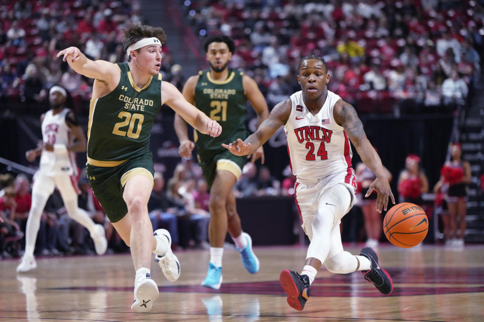 UNLV guard Jackie Johnson III (24) dribbles the ball next to Colorado State guard Joe Palmer (20) during the first half of an NCAA college basketball game Saturday, Feb. 24, 2024, in Las Vegas. (AP Photo/Lucas Peltier)