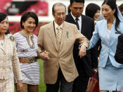 FILE - In this April 29, 2007, file photo, Macao tycoon and owner of Hong Kong horse Viva Pataca Stanley Ho, center, gets a little help from his wife Angela Leung, second left, and an attendant during awarding ceremony at the Sha Tin racecourse in Hong Kong. On Tuesday, May 26, 2020, the family of Stanley Ho, the Macao casino tycoon considered the father of modern gambling in China, has died at 98. (AP Photo/Vincent Yu, File)