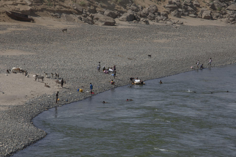 Few Tigrayan refugees swim across the banks of the Tekeze River, on the Ethiopia-Sudan border after Ethiopian forces blocked people from crossing into Sudan, in Hamdayet, eastern Sudan, Tuesday, Dec. 15, 2020. (AP Photo/Nariman El-Mofty)