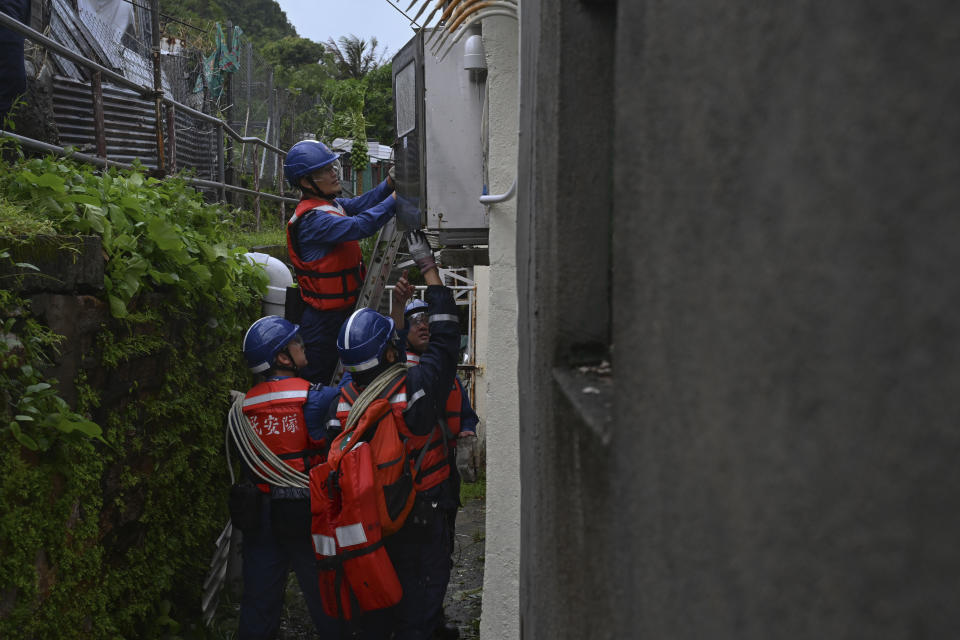 A rescue team checks an electrical box during Typhoon Saola in Lei Yue Mun district in Hong Kong, on Saturday, Sept. 2, 2023. Typhoon Saola made landfall in southern China before dawn Saturday after nearly 900,000 people were moved to safety and most of Hong Kong and other parts of coastal southern China suspended business, transport and classes. (AP Photo/Billy H.C. Kwok)