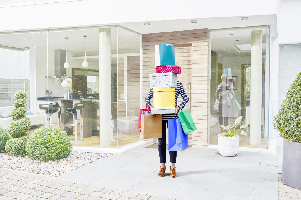 Woman holding piles of shopping boxes