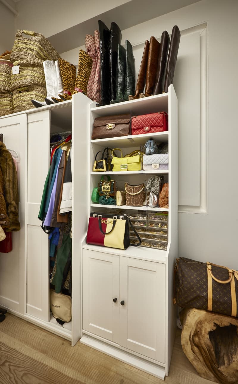 Designer handbags line closet.