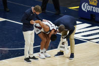 Gonzaga coach Mark Few, left, helps Jalen Suggs (1) as he is examined during the first half of the team's NCAA college basketball game against West Virginia, Wednesday, Dec. 2, 2020, in Indianapolis. (AP Photo/Darron Cummings)