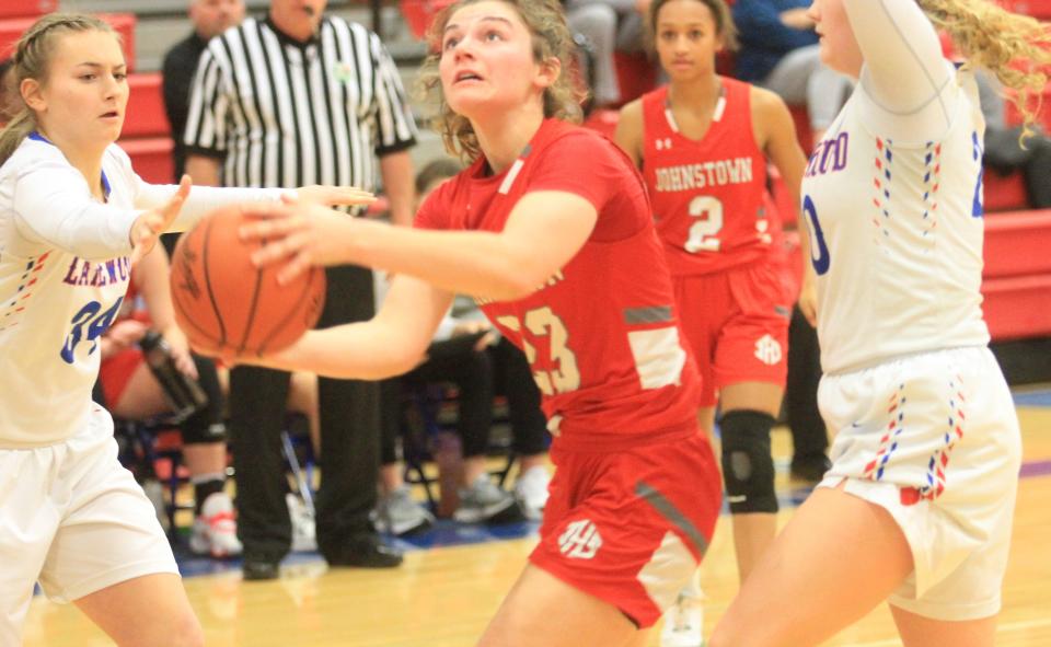 Johnstown junior Abigail Adkins splits Lakewood defenders senior McKenna Clem and sophomore Charlee Palmer on Saturday, Jan. 21, 2023. Adkins scored 22 points to lift the visiting Johnnies to a 53-51 victory.