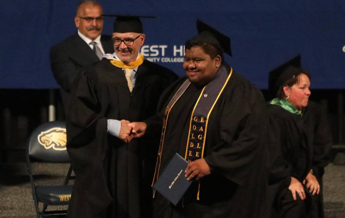 West Hills College Lemoore President James Preston congratulates TikTok superstar Leo González during May 25, 2023 commencement at Golden Eagle Arena.