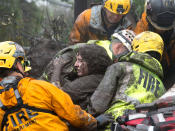 <p>Emergency personnel carry a woman rescued from a collapsed house after a mudslide in Montecito, Calif., Jan. 9, 2018. (Photo: Kenneth Song/Santa Barbara News-Press via Reuters) </p>