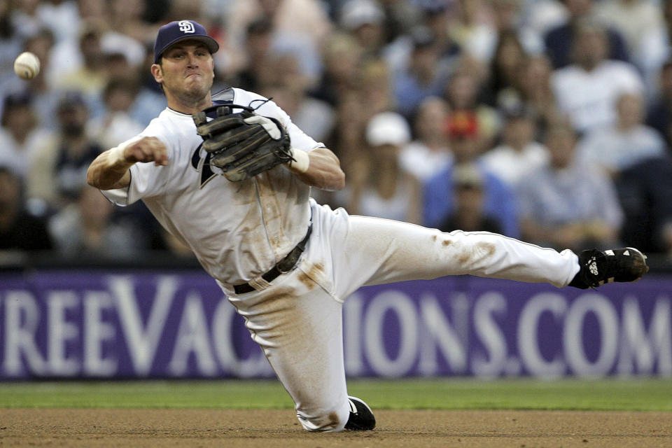 FILE- San Diego Padres third baseman Sean Burroughs fires a throw to first from his knees but is unable to get Los Angeles Dodgers' D. J. Houlton at first during the third inning of a baseball game June 22, 2005, in San Diego. Burroughs, a two-time Little League World Series champion who won an Olympic gold medal and went on to a major league career that was interrupted by substance abuse, has died. He was 43. The Los Angeles County Medical Examiner’s online records said Burroughs died Thursday, May 9, 2024, with the cause of death deferred. (AP Photo/Lenny Ignelzi, File)