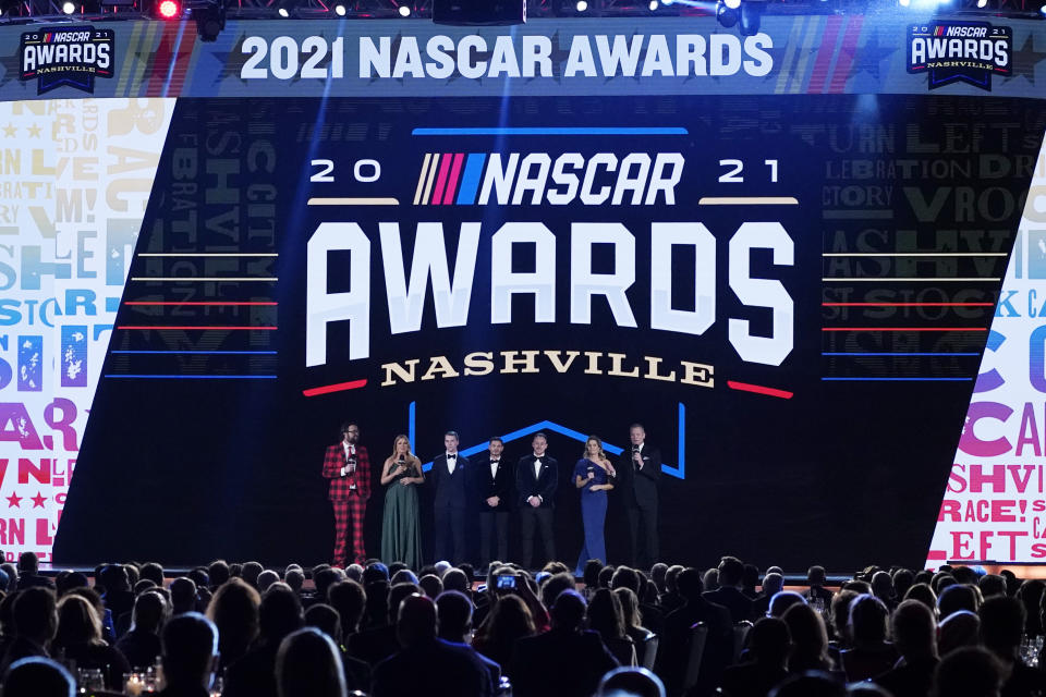 Series champions Ben Rhodes, third from left; Kyle Larson, center; and Daniel Hemric, third from right, join the hosts on stage at the end of the NASCAR Awards on Thursday, Dec. 2, 2021, in Nashville, Tenn. (AP Photo/Mark Humphrey)