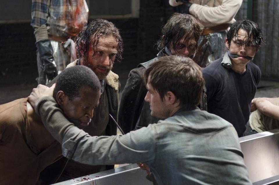 rick, daryl, glenn, and bob are on their knees and gagged at terminus 