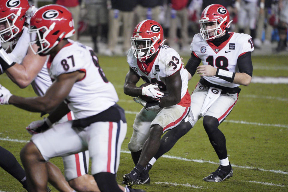 Georgia running back Daijun Edwards (33) takes a handoff from JT Daniels (18) during the second half of the team's NCAA college football game against South Carolina on Saturday, Nov. 28, 2020, in Columbia, S.C. Georgia won 45-16. (AP Photo/Sean Rayford)