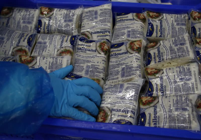 Workers pack halloumi cheese at the Petrou Bros Dairy in Aradippou