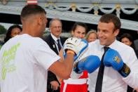 French President Emmanuel Macron (R) spars with a boxer in Paris, France, June 24, 2017. REUTERS/Jean-Paul Pelissier