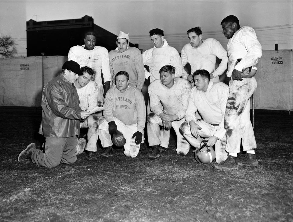 Coach Paul Brown, wearing baseball cap at lower left, poses with Cleveland Browns players on Dec. 23, 1952. At front from left: Dante Lavelli, Lin Houston, Frank Gatski, and George Young. Standing, from left: Marion Motley, Otto Graham, Mac Speedie, Lou Groza and Bill Willis.