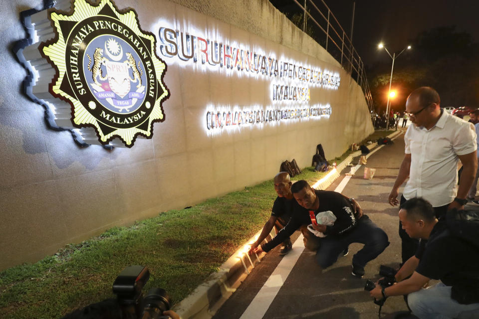 <p>Supporters of former Prime Minister Najib Razak seen lighting candles outside the Malaysian Anti-Corruption Commission headquarters on Tuesday (3 July) night. (PHOTO: Associated Press) </p>