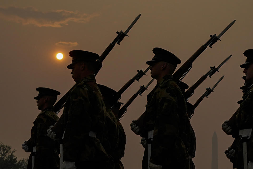 Members of the Marine Corps honor color guard rehearse near the Reflecting Pool with the sun rising over a thick layer of smoke, Thursday, June 8, 2023, in Washington. Intense Canadian wildfires are blanketing the northeastern U.S. in a dystopian haze, turning the air acrid, the sky yellowish gray and prompting warnings for vulnerable populations to stay inside. (AP Photo/Julio Cortez)