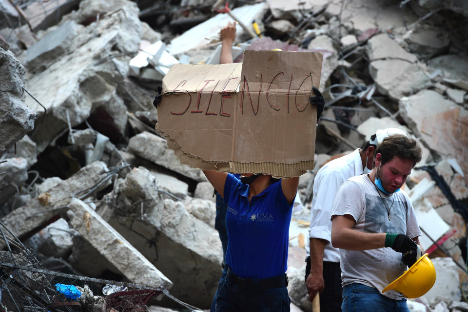 Rescuers searching for survivors buried under the rubble ask for silence to help locate those who&nbsp;may be trapped.