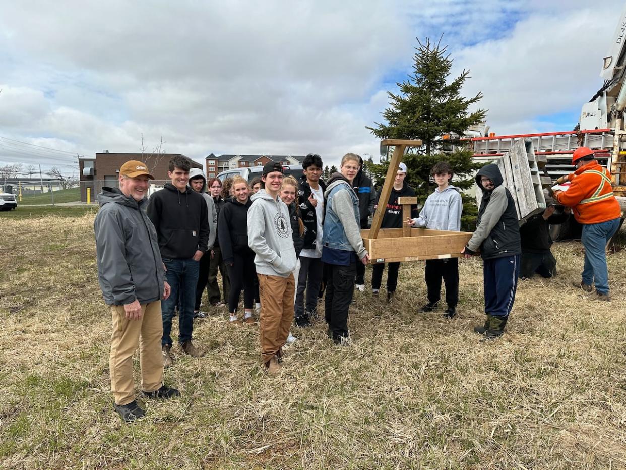 Environmental science teacher Rob Redmond, left, and his students just before the platform and pole were installed outside Charlottetown Rural High School.  (Aaron Adetuyi/CBC - image credit)
