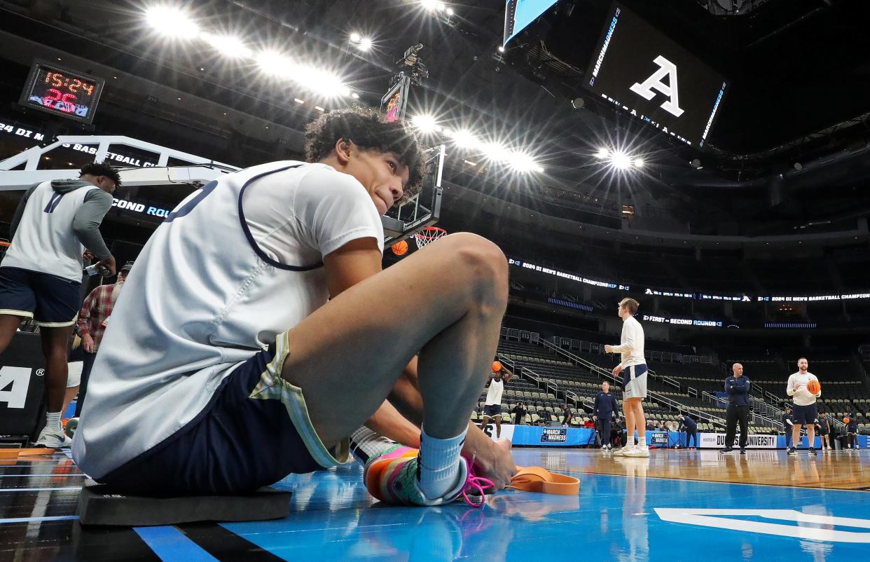 Akron's Enrique Freeman (25) stretches under the bright lights of PPG Paints Arena during an open practice Wednesday in preparation for the Zips' first-round NCAA Tournament game against Creighton on Thursday in Pittsburgh.