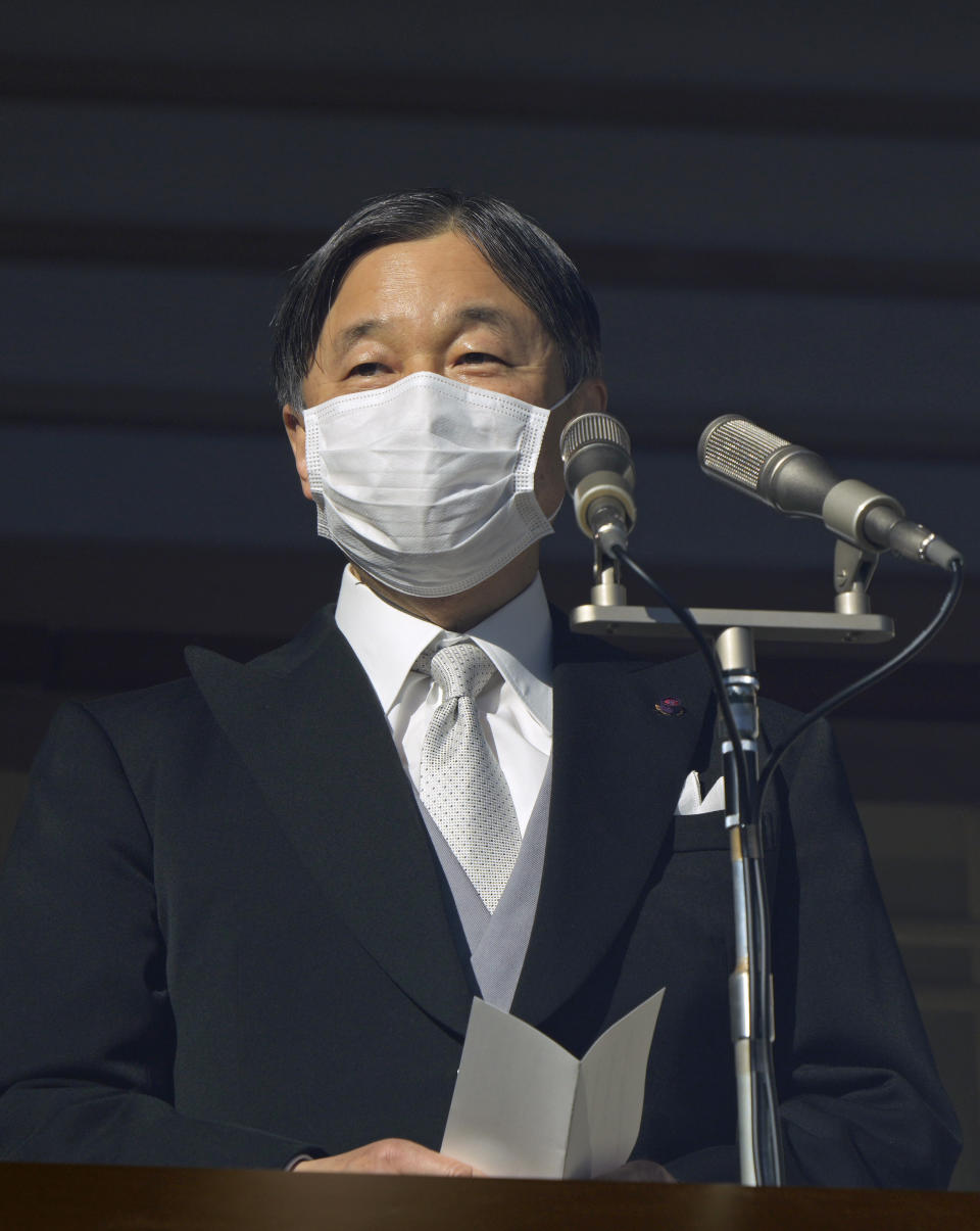 Japan's Emperor Naruhito delivers an address to well-wishers through a bullet-proof glass from a balcony during their New Year's public appearance at the Imperial Palace in Tokyo Monday, Jan. 2, 2023. The annual celebration returned after a two-year hiatus for coronavirus restrictions. (Franck Robichon/Pool Photo via AP)