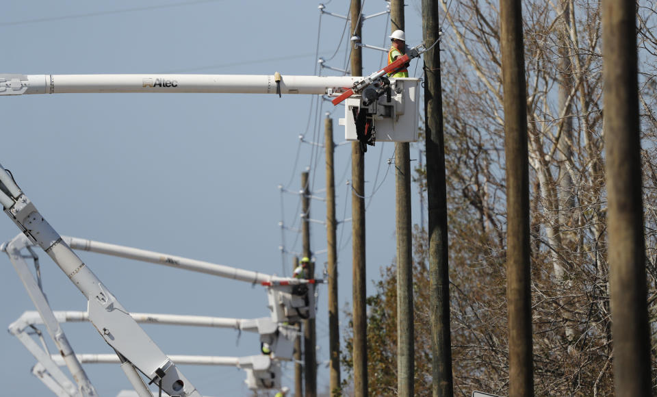 In this Thursday, Oct. 18, 2018 photo, utility crews set up new poles and utility wires in the aftermath of Hurricane Michael in Panama City, Fla. It's the greatest need after a hurricane and sometimes the hardest one to fulfill: Electricity. More than a week after Hurricane Michael smashed into the Florida Panhandle on a path of destruction that led all the way to the Georgia border, more than 100,000 Florida customers were still without power, according to the state Department of Emergency Management website. (AP Photo/Gerald Herbert)