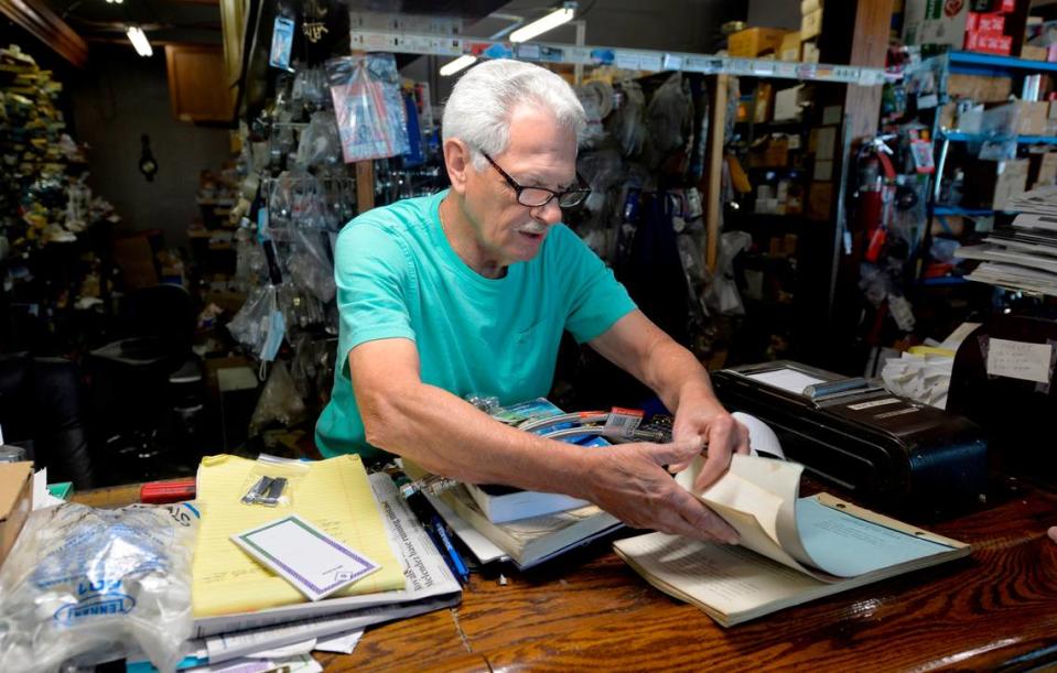 Graham checks some notes while helping a customer. His plumbing supply business moved from midtown Kansas City to Raytown in 1999.