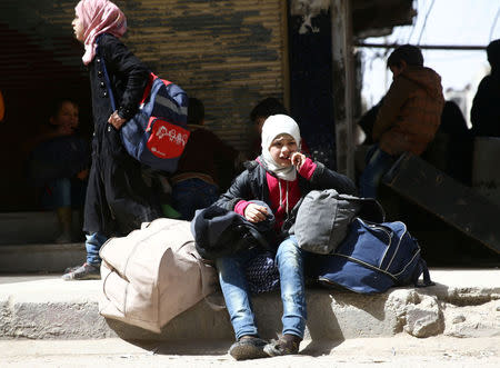 A girl holds her belongings during evacuation from the besieged town of Douma, Eastern Ghouta, in Damascus, Syria March 22, 2018. REUTERS/Bassam Khabieh