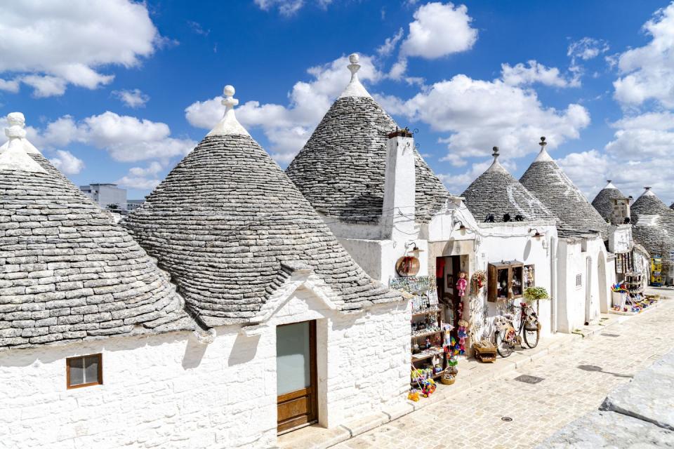 traditional whitewashed trulli houses in summer, alberobello, province of bari, apulia, italy