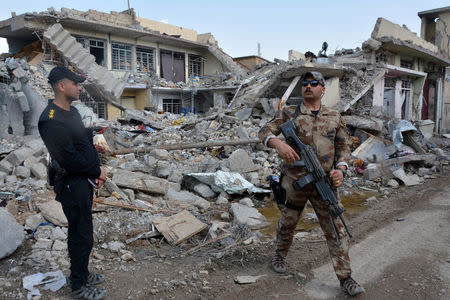 Members of the Counter Terrorism Service (CTS) stand at the site after an air strike attack against Islamic State triggered a massive explosion in Mosul, Iraq March 29, 2017. REUTERS/Stringer FOR EDITORIAL USE ONLY. NO RESALES. NO ARCHIVES.