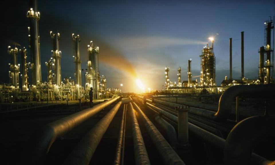 Gas fires light the night sky at the heavily lit Ras Tanurah oil refinery in Saudi Arabia