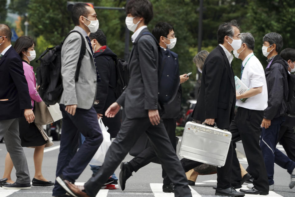 People wearing protective masks to help curb the spread of the coronavirus walk Monday, Nov. 2, 2020, in Tokyo. The Japanese capital confirmed more than 80 new coronavirus cases on Monday. (AP Photo/Eugene Hoshiko)