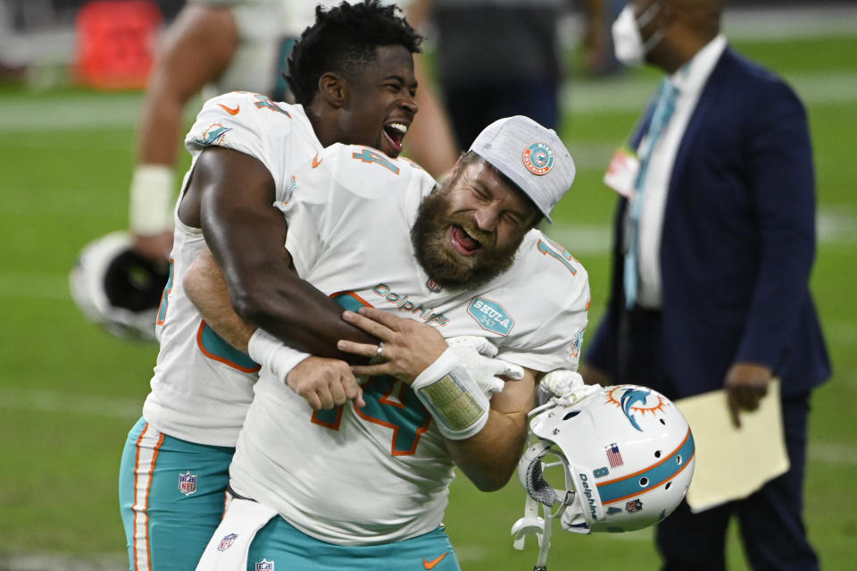 FILE - Miami Dolphins wide receiver Isaiah Ford, left, celebrates with quarterback Ryan Fitzpatrick after defeating the Las Vegas Raiders in an NFL football game, Saturday, Dec. 26, 2020, in Las Vegas. Quarterback Ryan Fitzpatrick confirmed to The Associated Press on Friday, June 3, 2022, that he informed former teammates of his intention to retire a day earlier. Former Bills running back Fred Jackson first announced the news of Fitzpatrick’s retirement on his Twitter account by posting an image and message from his former Buffalo teammate. (AP Photo/David Becker, File)