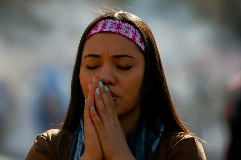 Una creyente reza durante la "Marcha por Jesús", un evento que reúne a un amplio abanico de congregaciones evangélicas, en Sao Paulo, Brasil, el 30 de mayo de 2024 (Miguel SCHINCARIOL)