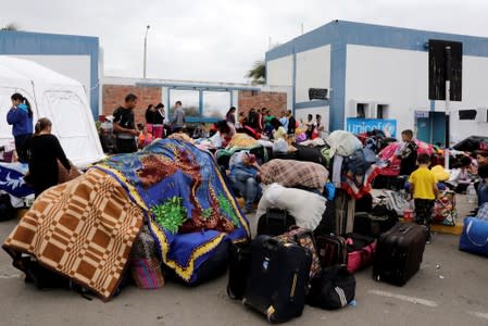 Venezuelan migrants wait for taxis after passing through the Binational Border Service Center of Peru, in Tumbes